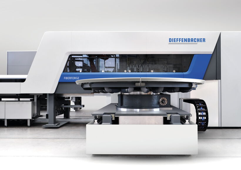 Frontansicht der Dieffenbacher Fiberforge mit rotierendem Ablagetisch und transparentem Prozessmodul für die automatisierte Herstellung von Faserverbund-Layups.