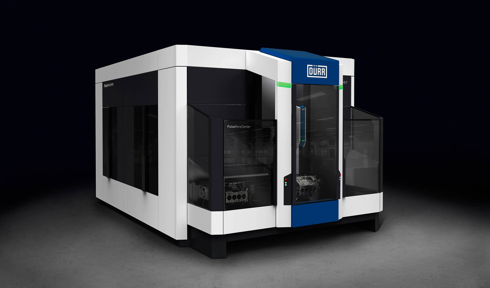 Dürr PulseBoreCenter Fertigungsanlage mit kubischem Maschinenbau-Design, großzügigen Glasflächen und zentral integrierter Prozesskammer für die Hochdruck-Wasserstrahlbearbeitung von Zylinderlaufbahnen.