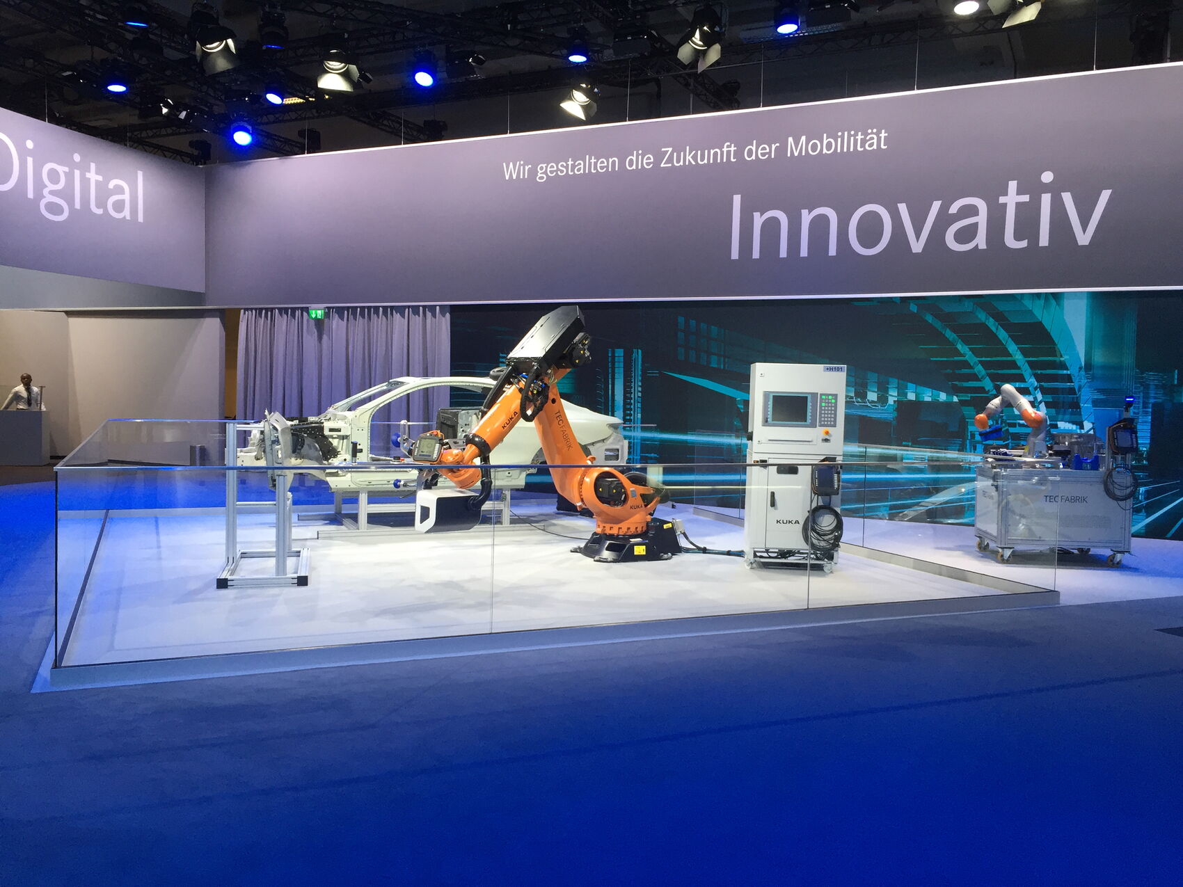 Daimler TecFabrik LeanFit Robotiksystem auf einer Fachmesse mit KUKA-Cobot und Fahrzeugkarosserie. Das mehrfach ausgezeichnete Montagesystem erhielt den iF Design Award sowie den Focus Open Silver Award.